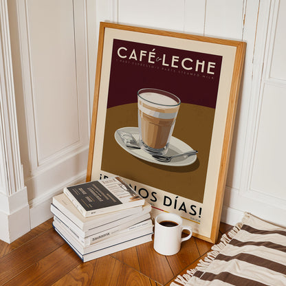 A framed poster of a latte on a plate, surrounded by a stack of books and a cup of coffee, is displayed on a wooden floor.