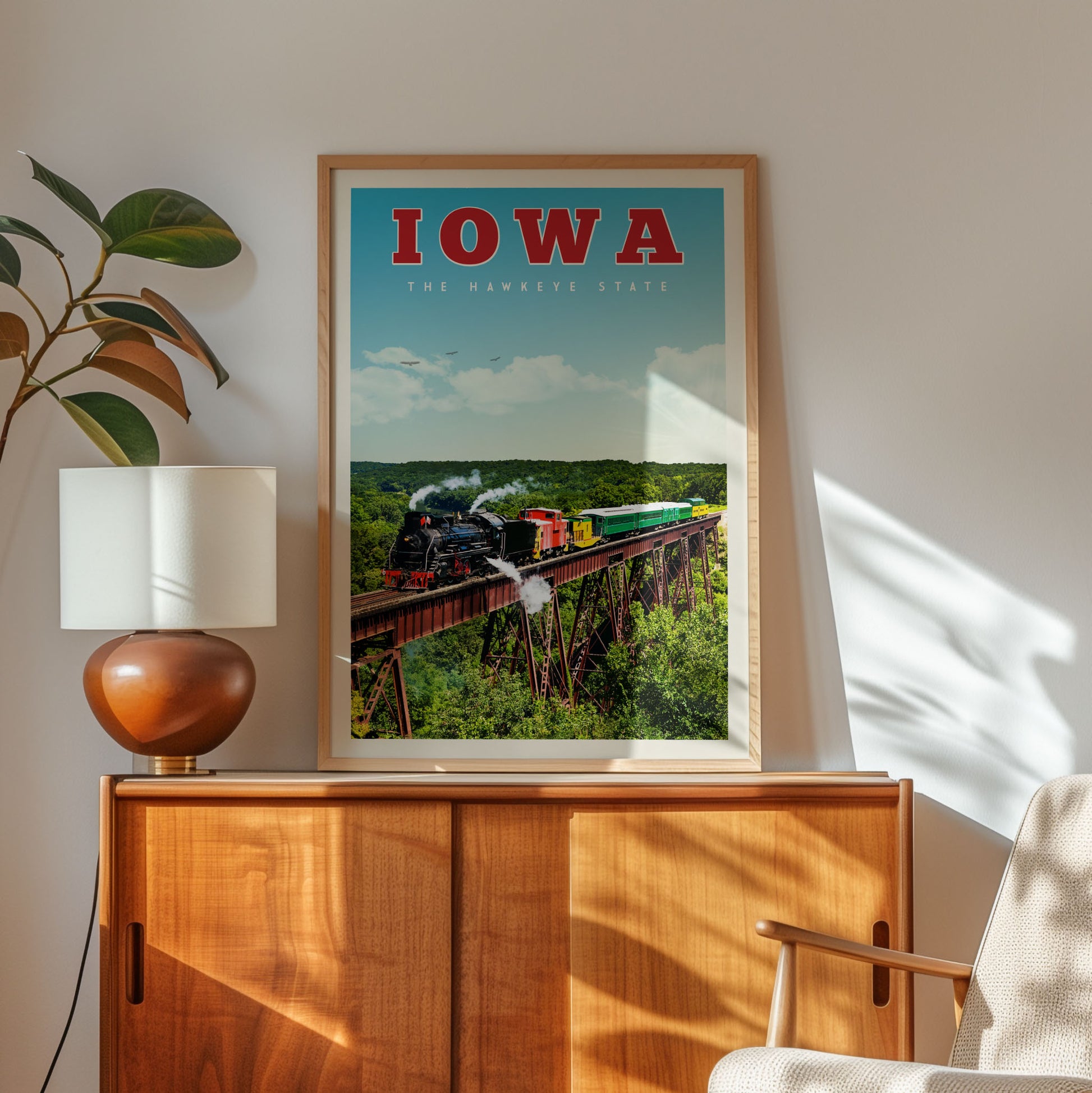 a framed poster of a train on a bridge, with the word "IOWA" prominently displayed.