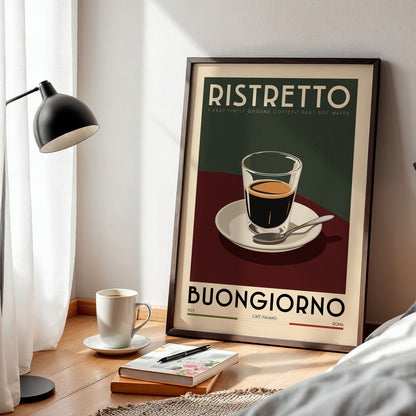 a framed poster of a cup of coffee with the text "RISTRETO" and "BUONGIORNO" printed on it, along with a cup of coffee and a book on a wooden table.