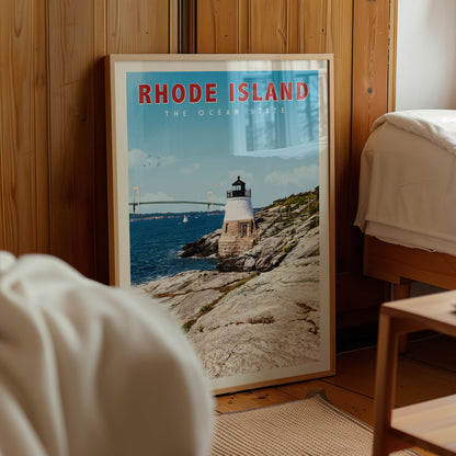 A framed poster of a lighthouse on a rocky coastline, with the text "RHODE ISLAND THE OCEAN STATE" prominently displayed.