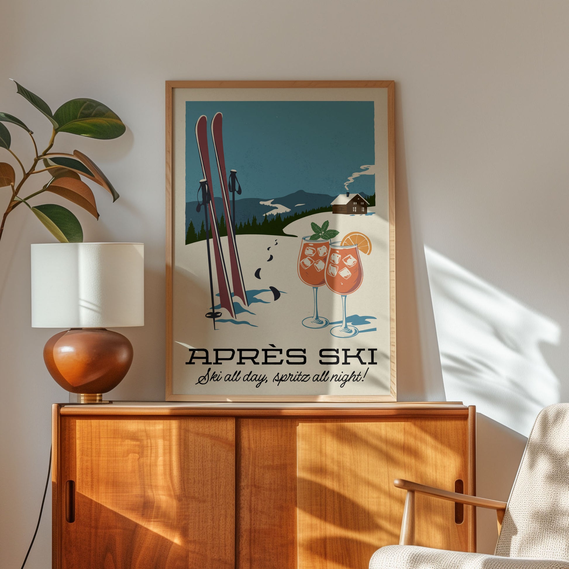 A framed poster of a ski resort with two skis and two glasses of what appears to be cocktails, along with the text "APRés Ski" and "Série all day, Spritz all night!"