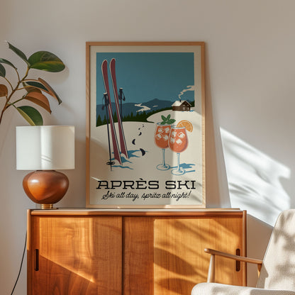 A framed poster of a ski resort with two skis and two glasses of what appears to be cocktails, along with the text "APRés Ski" and "Série all day, Spritz all night!"