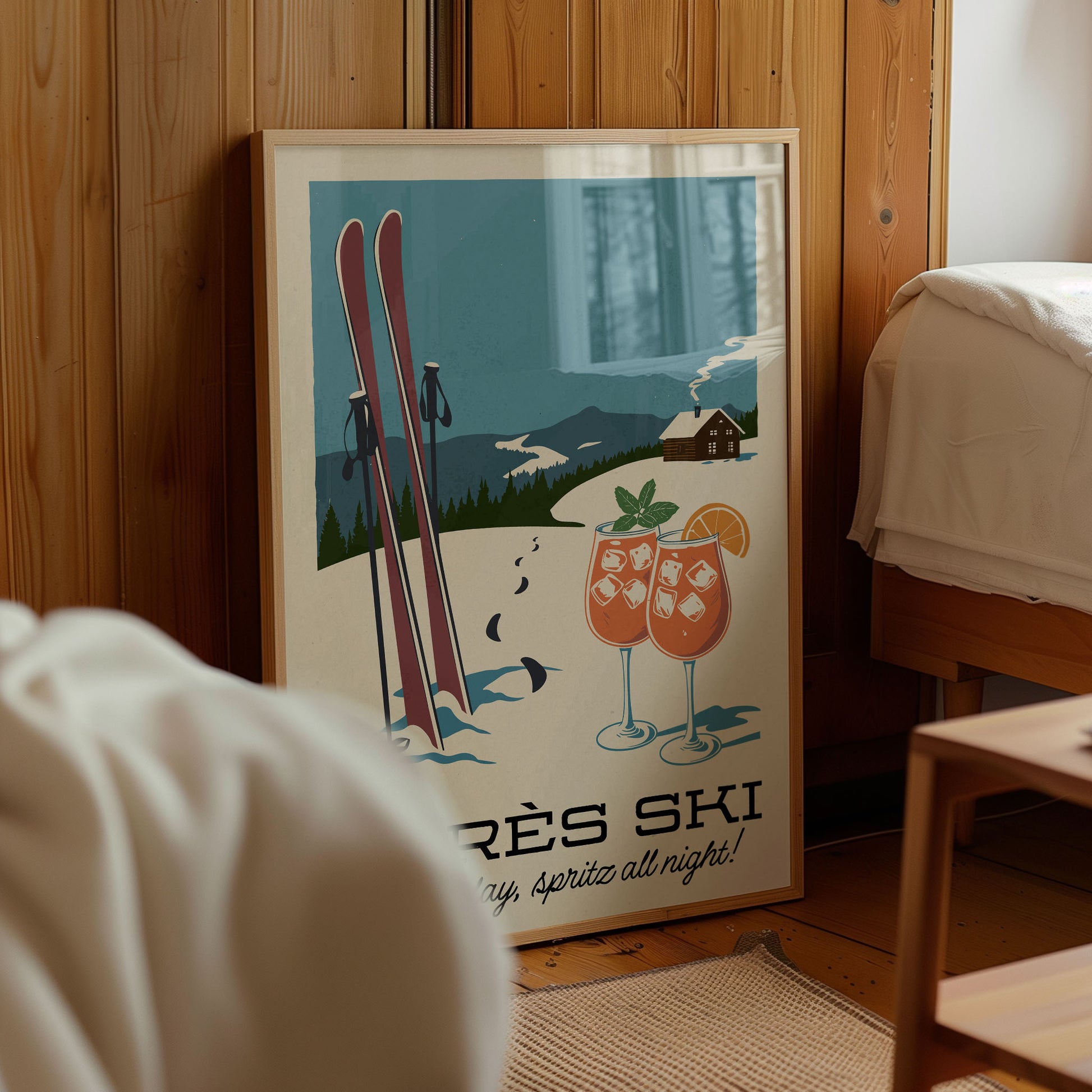 A framed poster with a winter scene depicting skis and two drinks, along with the text "Skiing" and "Spirits all night!"