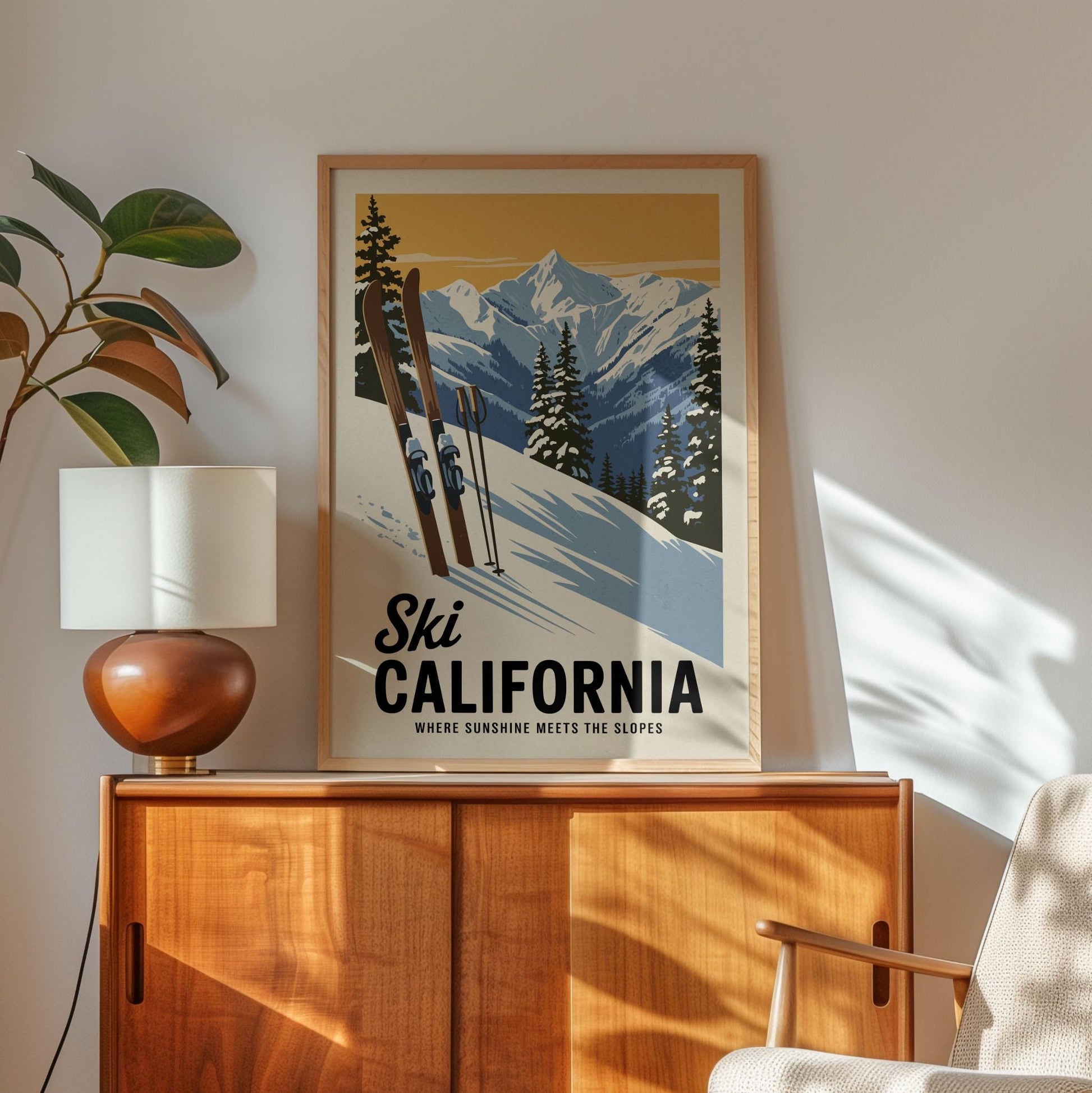 A framed poster of a snowy mountain landscape with skiers is displayed on a wooden cabinet, accompanied by a lamp and a plant in the corner of the room.