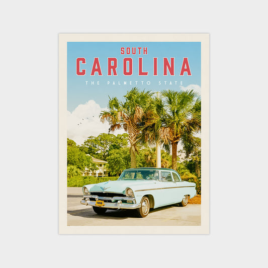 A vintage light blue car is parked in front of a palm tree, with the text "SOUTH CAROLINA" and "THE PALMETTO STATE" displayed prominently above the car.