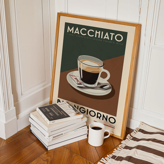a framed poster of a cup of coffee with the text "MACCHIATO" and "I SPOT ESPRESSO! 1 SPON FOAMED MILK" on it, along with a stack of books and a white mug on the floor.
