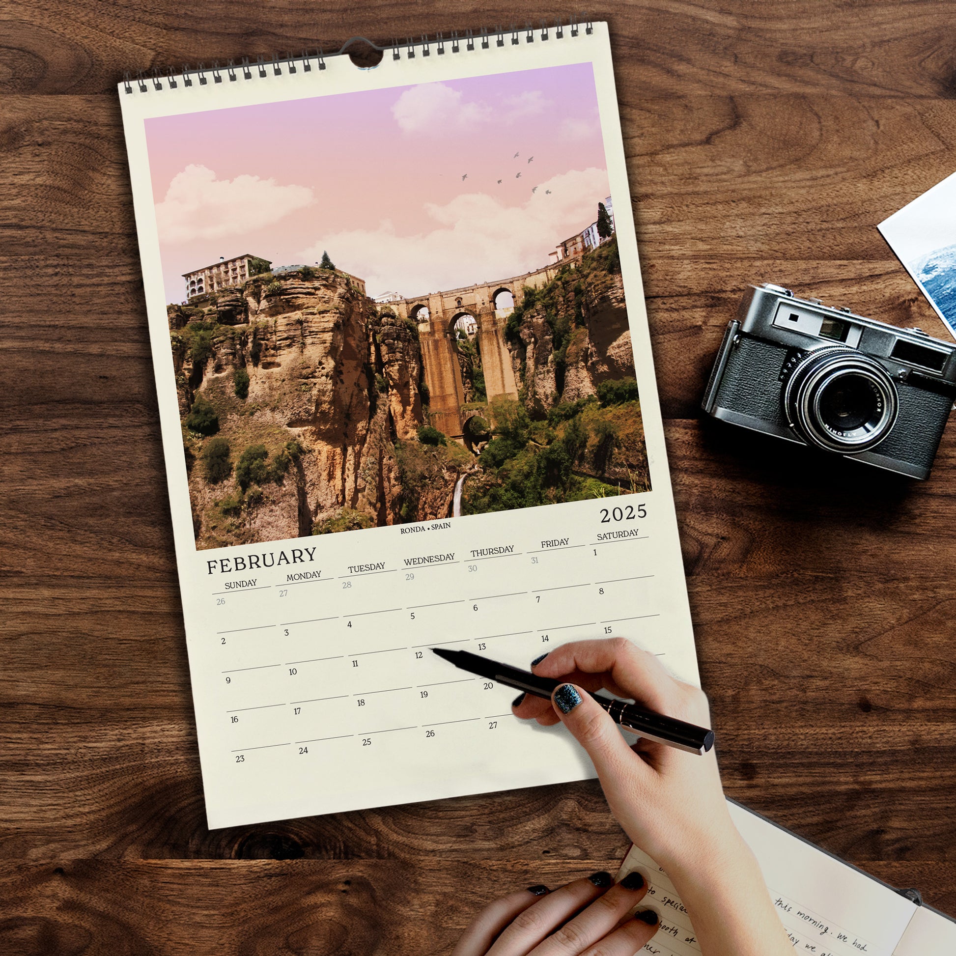 a person holding a pen and a calendar on a table