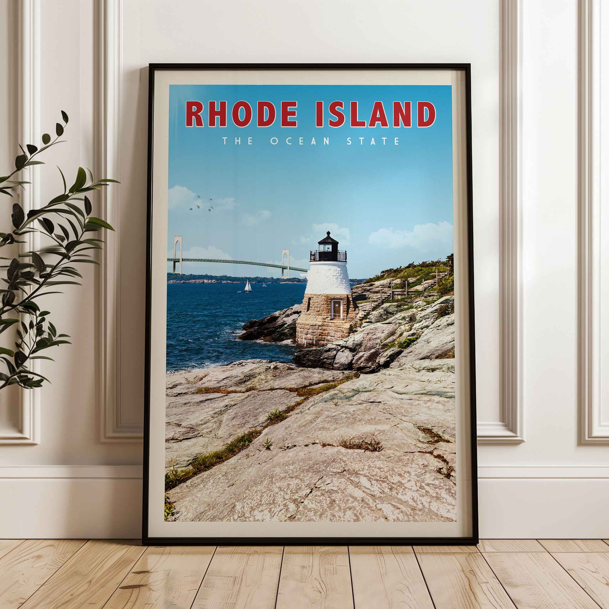 A framed poster of a lighthouse on a rocky coastline, with a bridge in the background, is displayed on a wall.