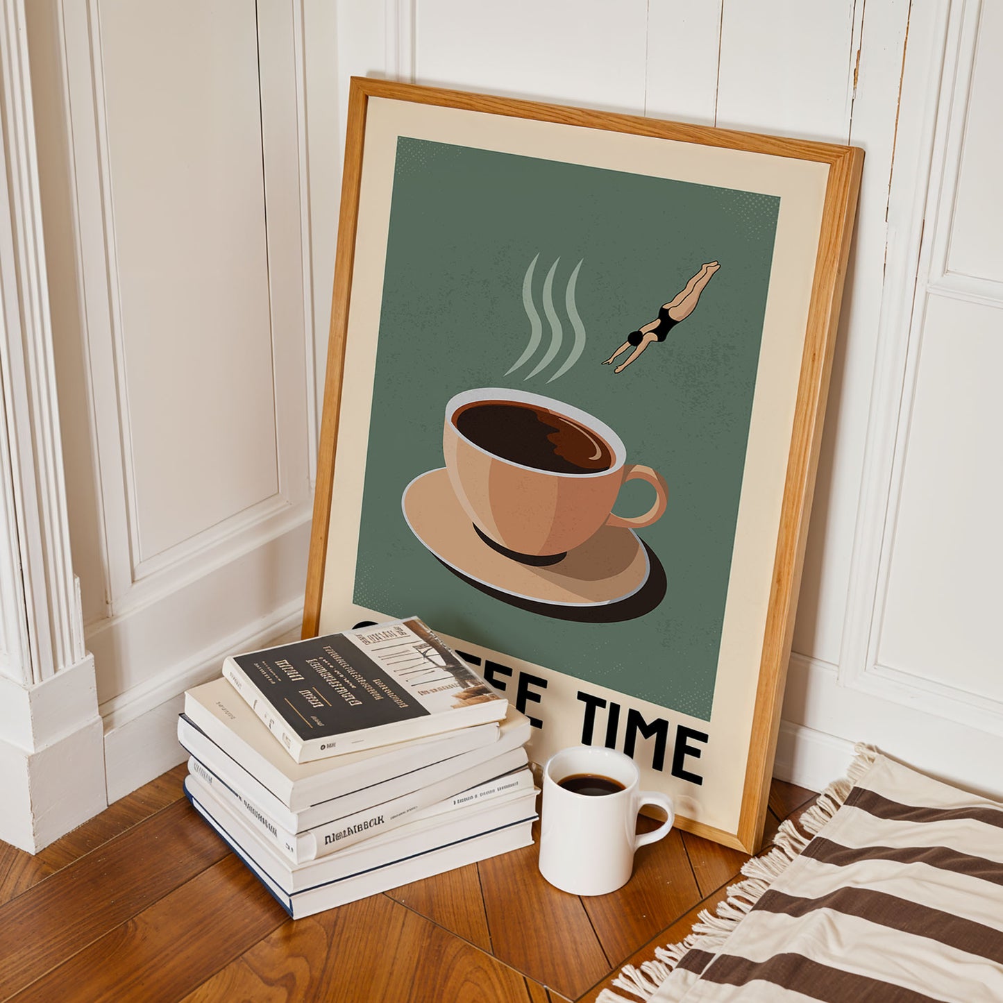 a framed poster with a coffee cup and a swimmer, along with a stack of books and a cup of coffee on a wooden floor.