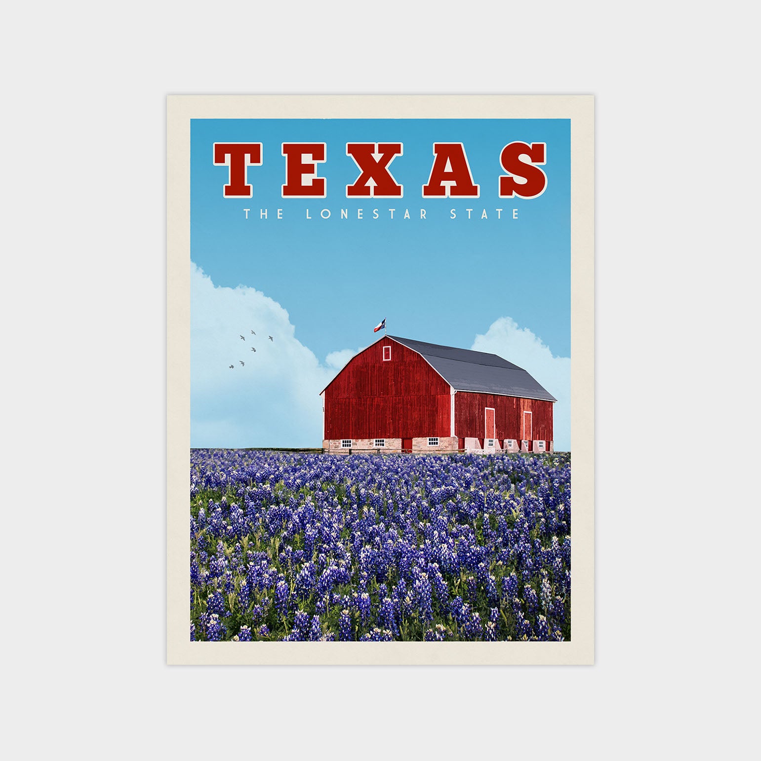 A red barn stands in a field of purple flowers, with a blue sky and fluffy white clouds above.
