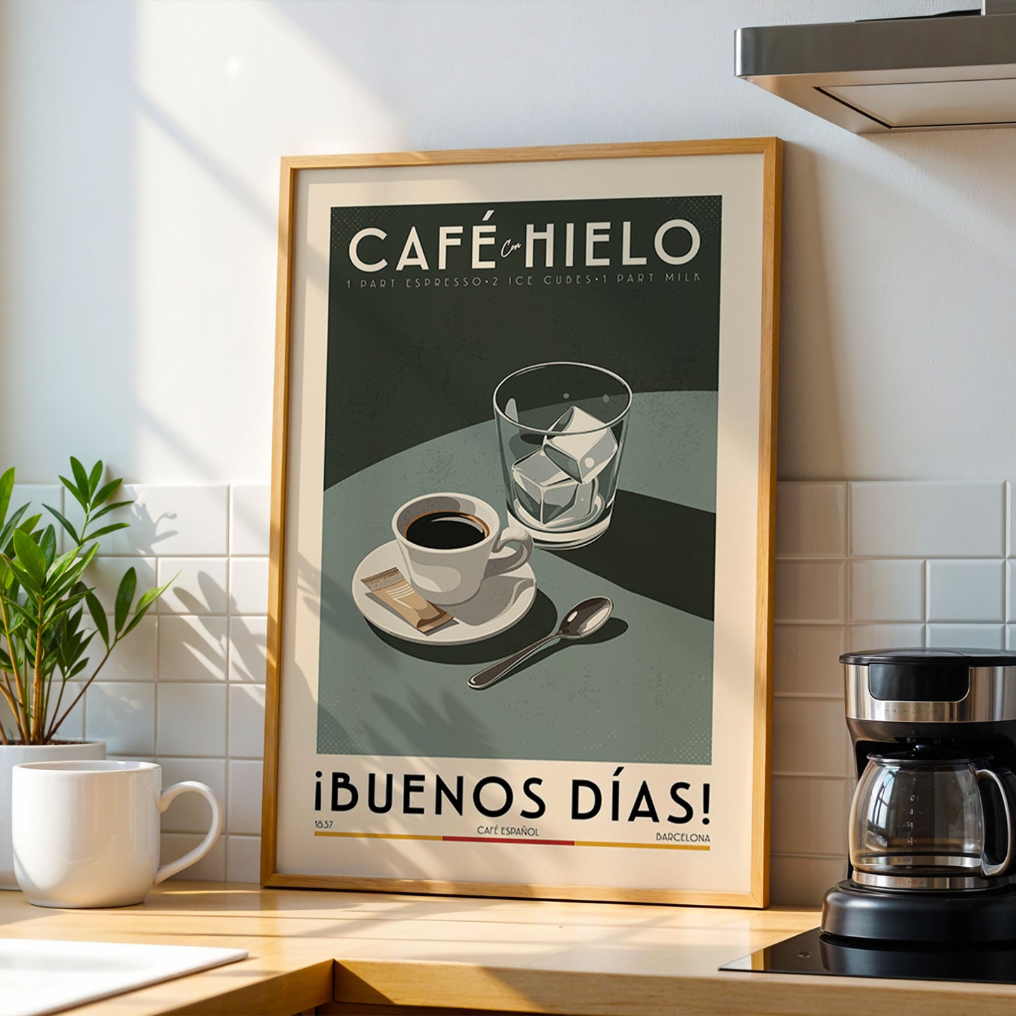 a framed poster of a coffee scene with a coffee cup, spoon, and sugar cubes, placed on a kitchen counter next to a coffee maker.