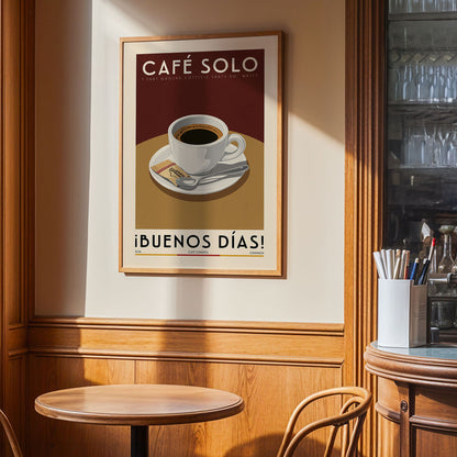 a framed poster of a cup of coffee on a table, with the text "Café Solo" and "ibunos dias!" written on it.
