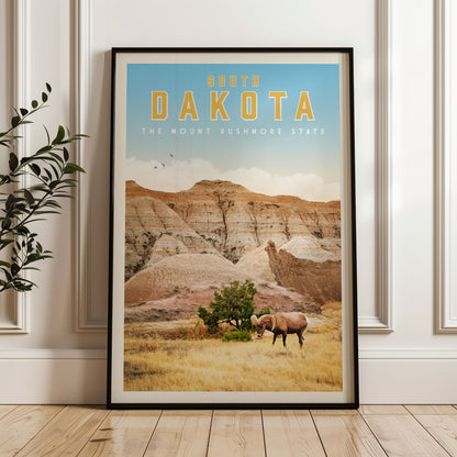 A framed poster of the scenic landscape of South Dakota, featuring a mountain range, a grazing animal, and a clear blue sky.