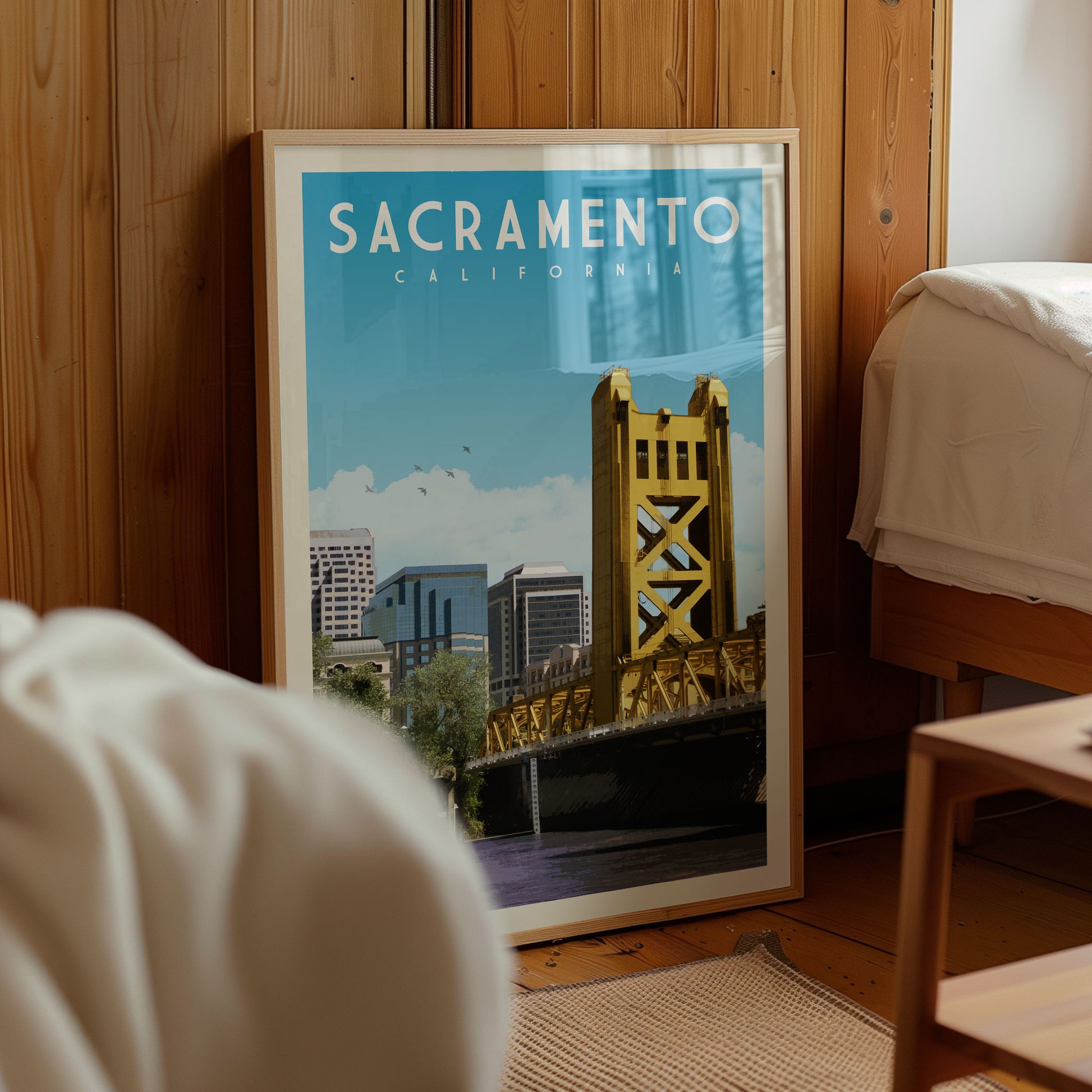 A framed poster of the Golden Gate Bridge in Sacramento, California, displayed in a room with wooden paneling.