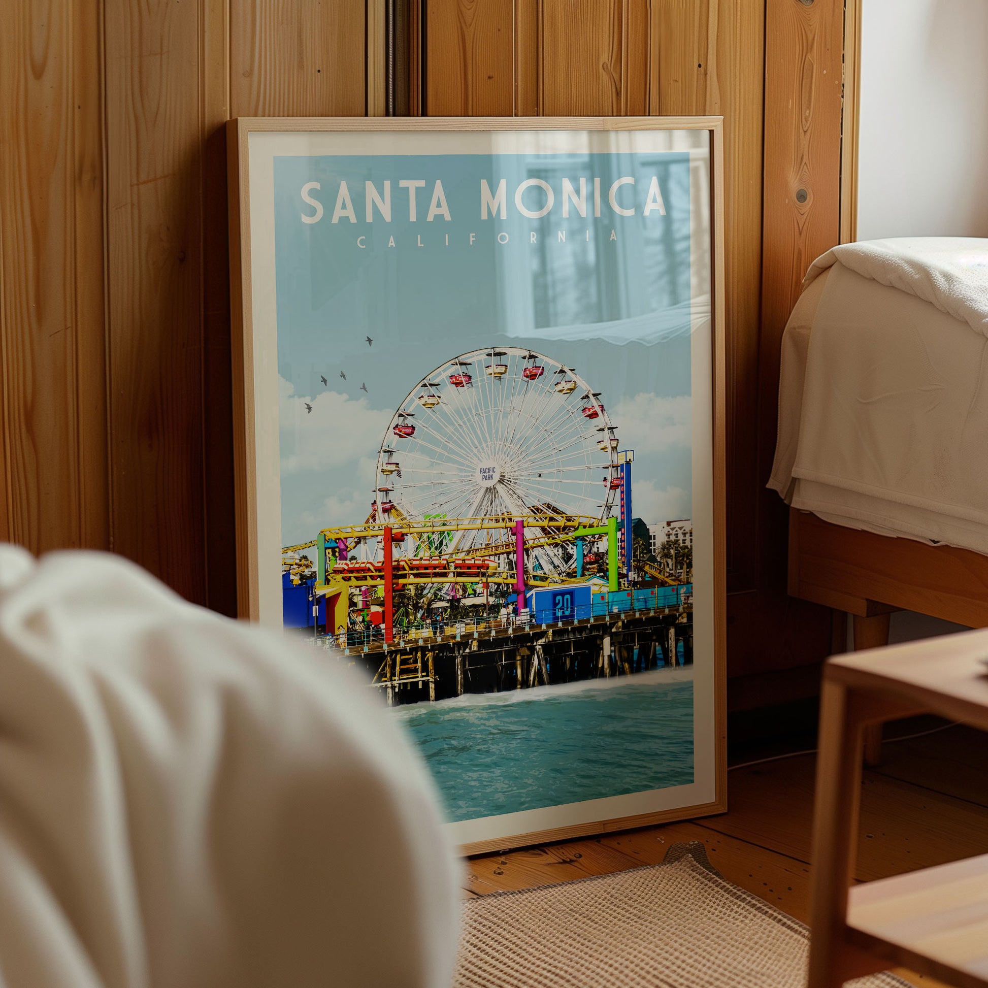 A framed poster of Santa Monica, California, featuring a ferris wheel and the ocean in the background.