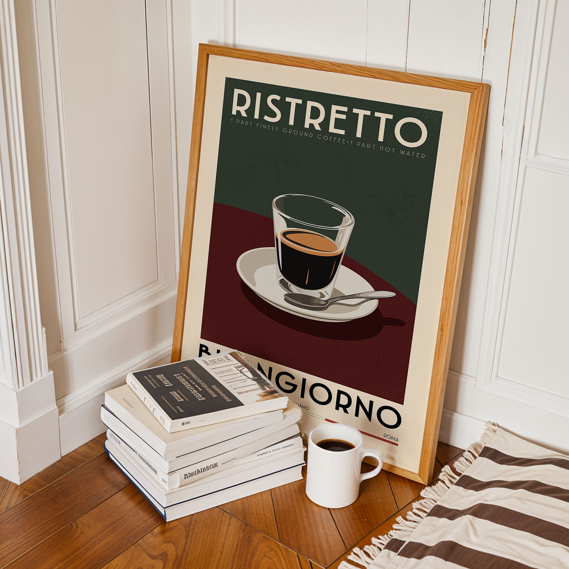 a framed poster of a cup of coffee with the text "RISTRETTO" and "BANGIGIORNO" on it, along with a stack of books and a white mug on the floor.