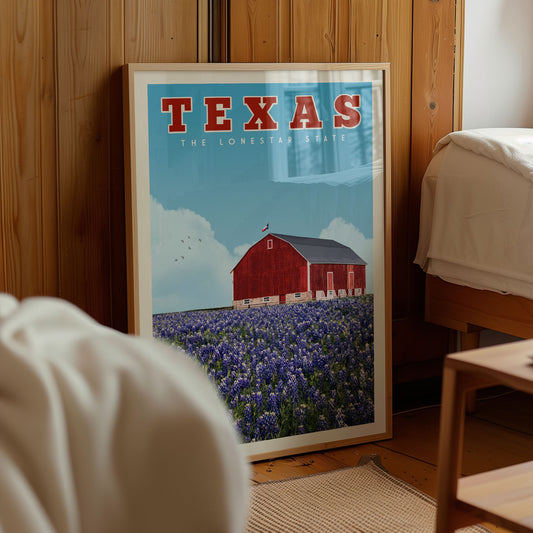 A framed poster of a red barn with a field of blue flowers in the background, located in a room with wooden walls.