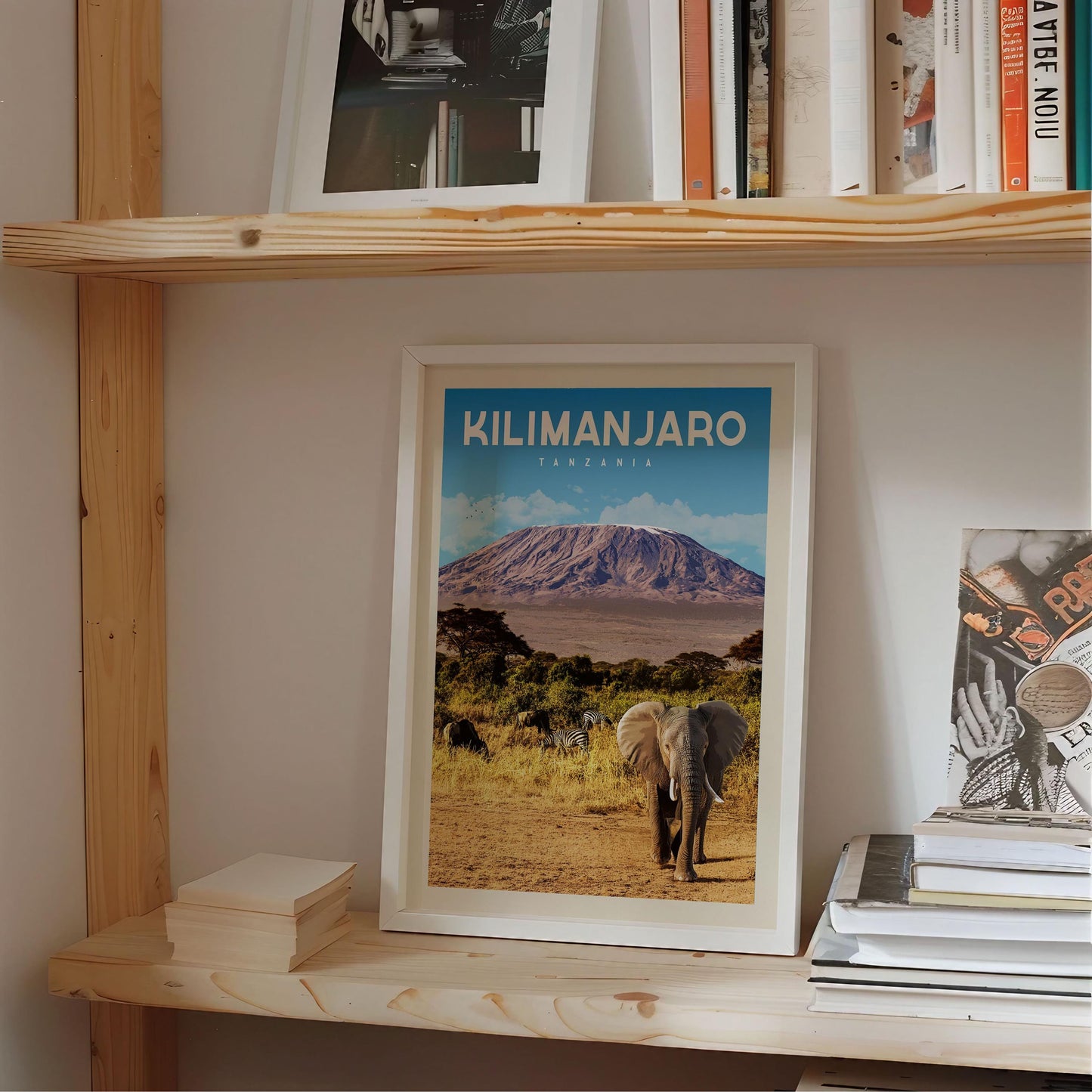 A framed poster of Kilimanjaro, the highest peak in Africa, is displayed on a shelf among other items.