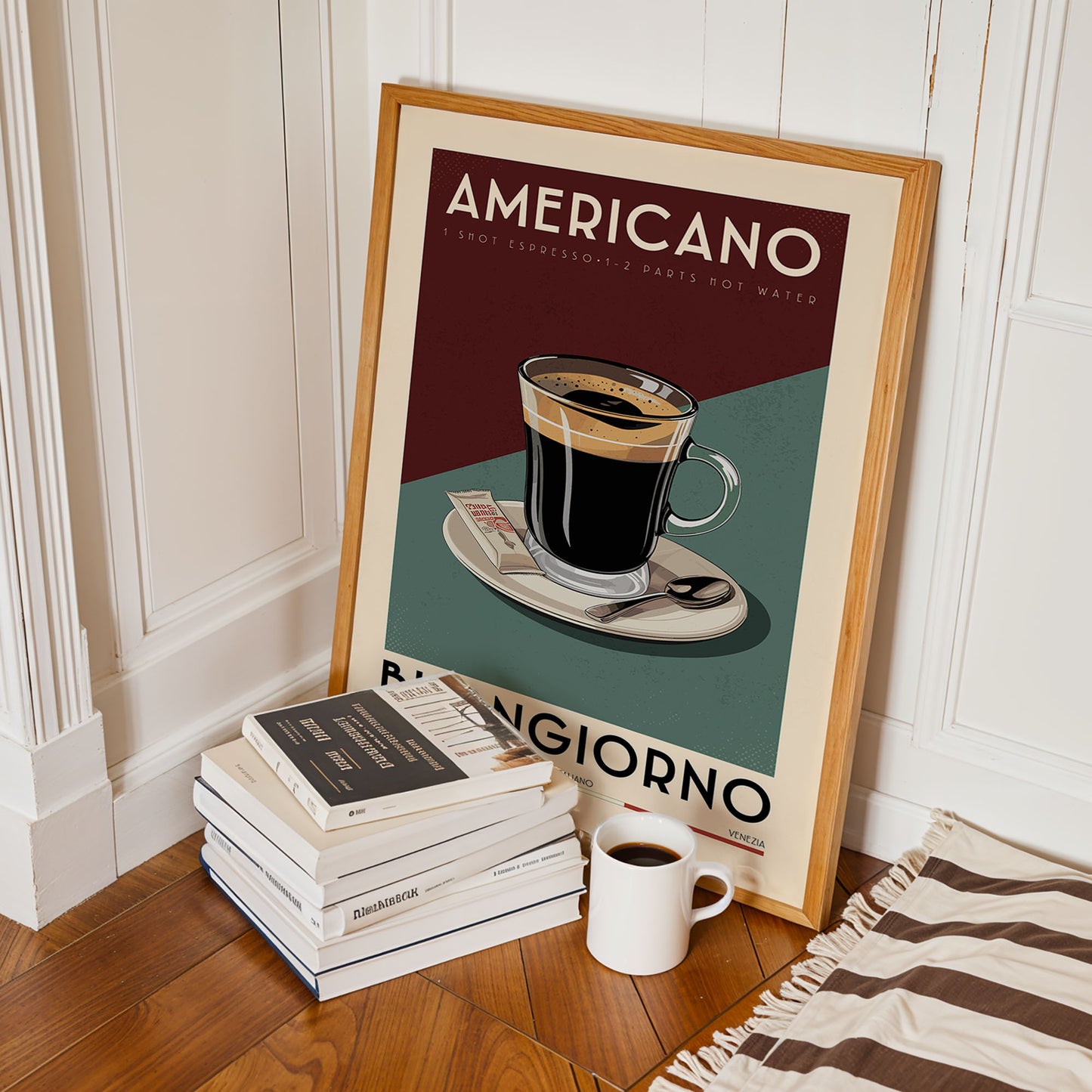 A framed poster of an americano coffee cup is leaning against a white wall, with a stack of books and a white mug on the floor in front of it.