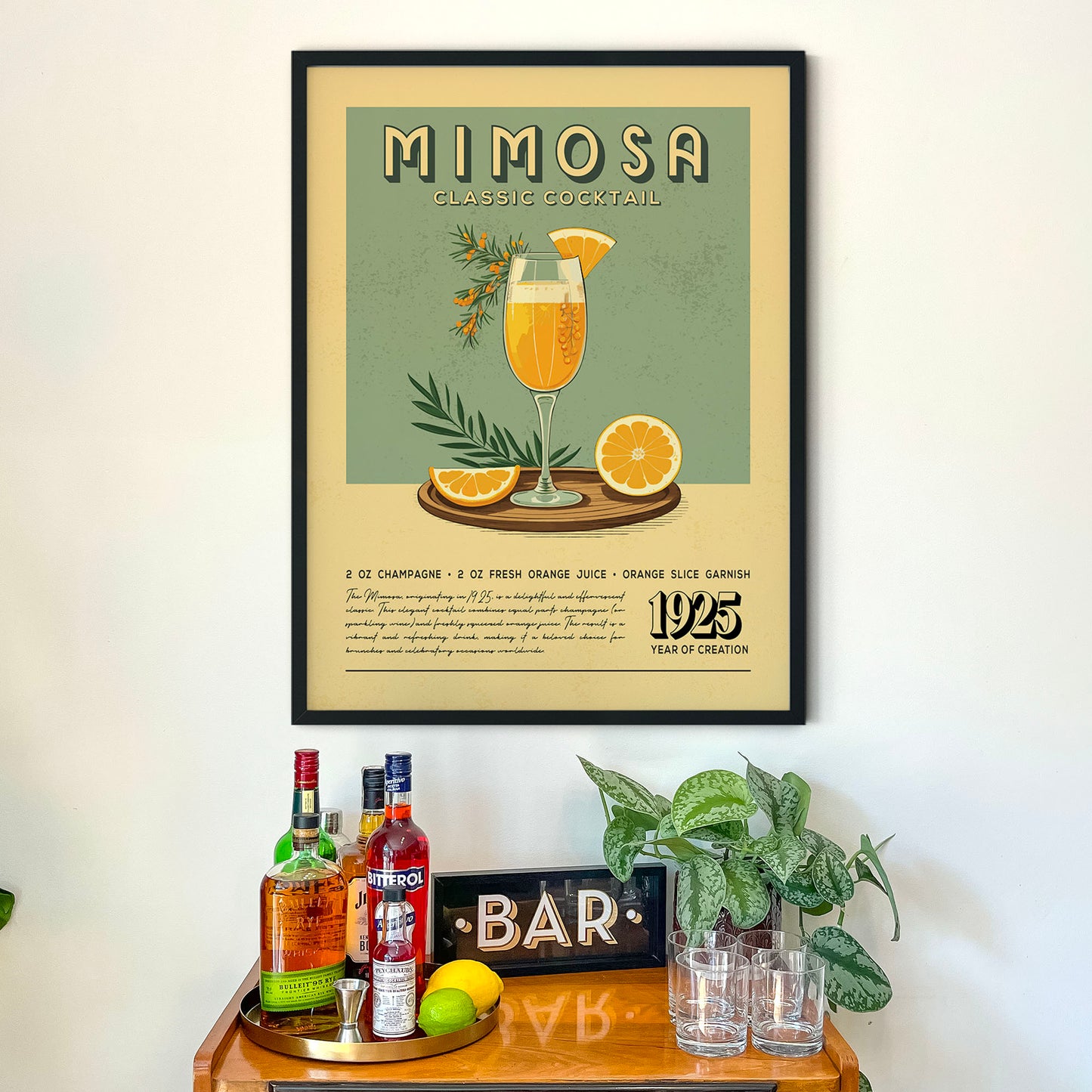 a framed poster of a mimosa cocktail hanging on a wall above a wooden bar counter with various liquor bottles and glasses.