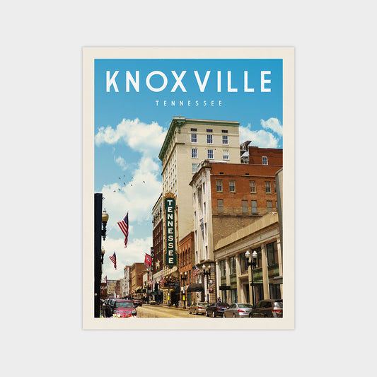 a city street in Knoxville, Tennessee, with tall buildings, cars, and people walking on the sidewalks.