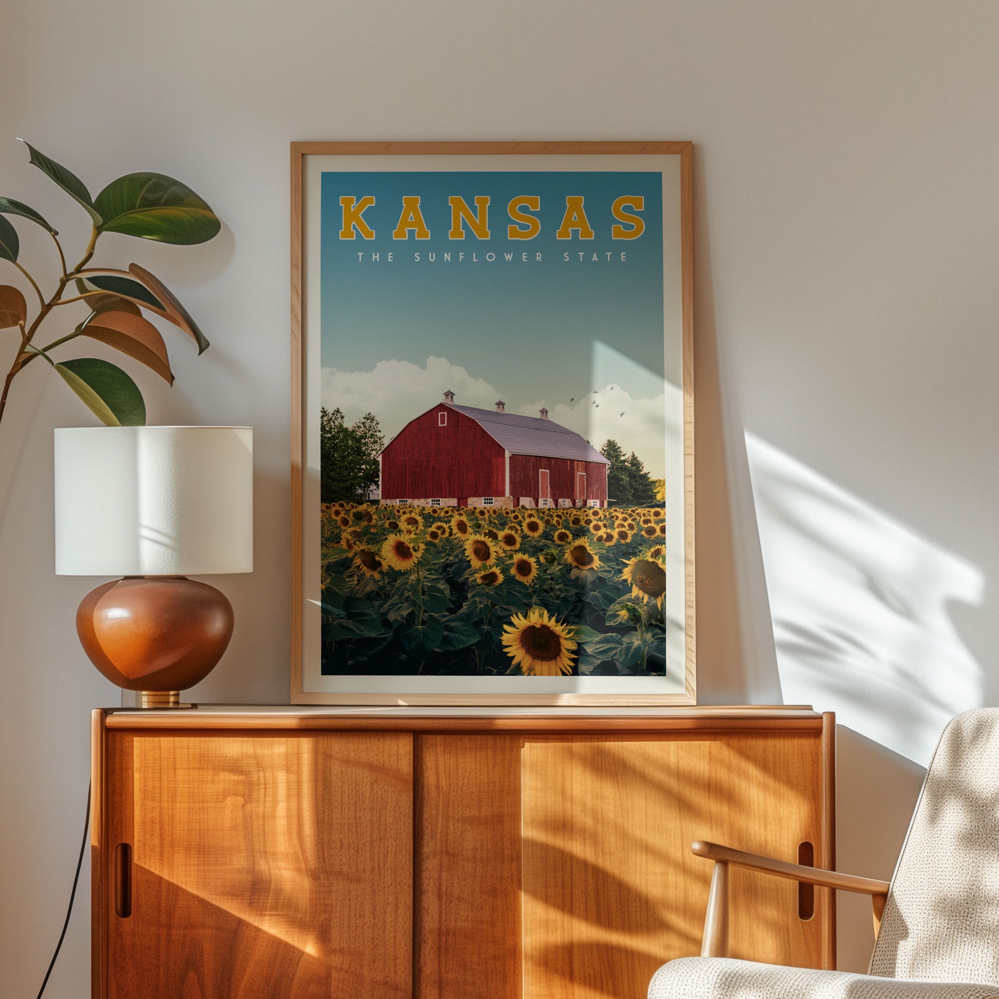 a framed poster of a red barn and a field of sunflowers, with the text "KANSAS THE SUNFLOWER STATE" prominently displayed.