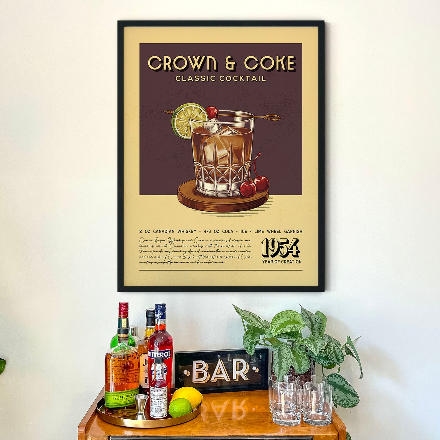 a framed poster of a classic Crown and Coke cocktail, along with a wooden bar display and various liquor bottles.