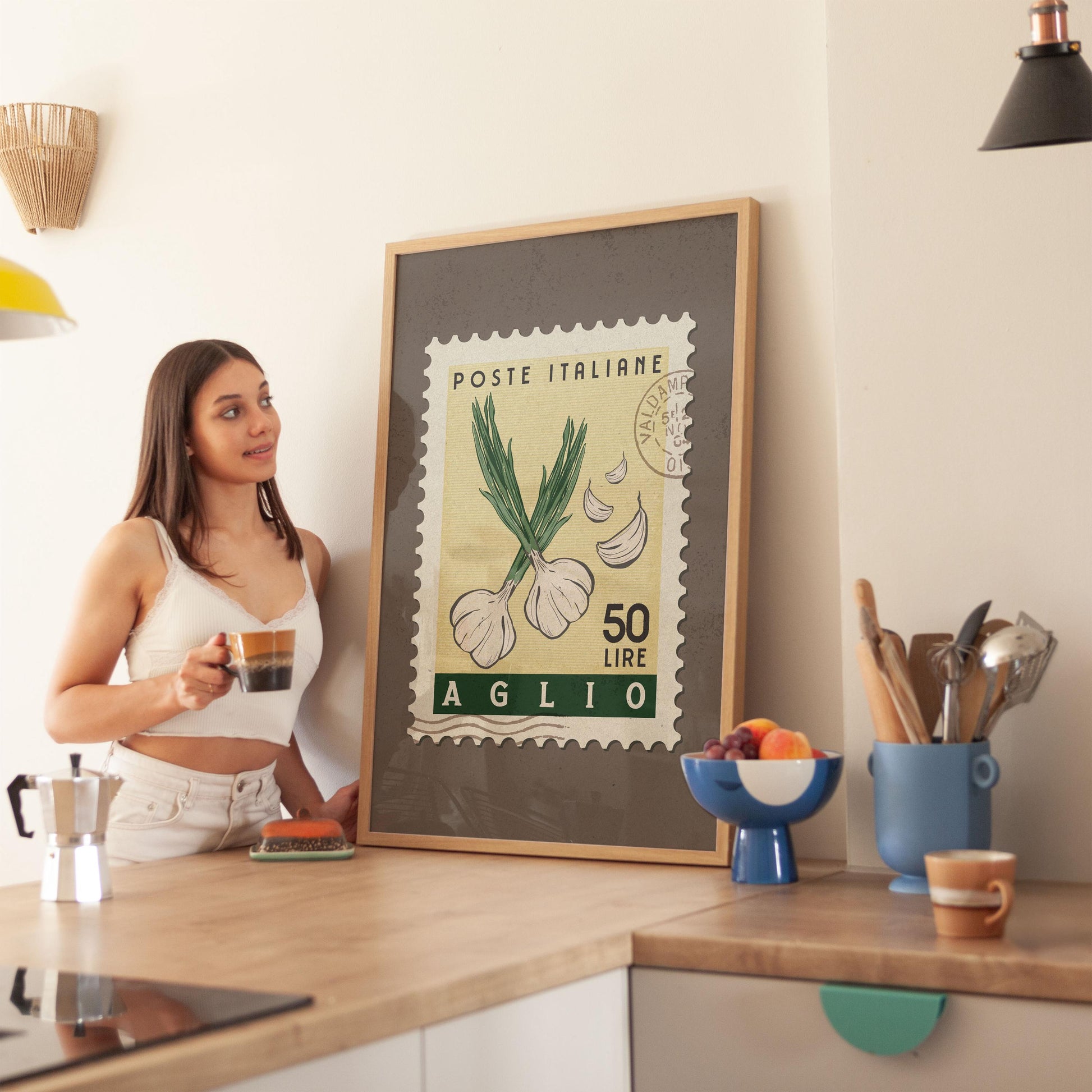 a woman standing in a kitchen next to a framed poster