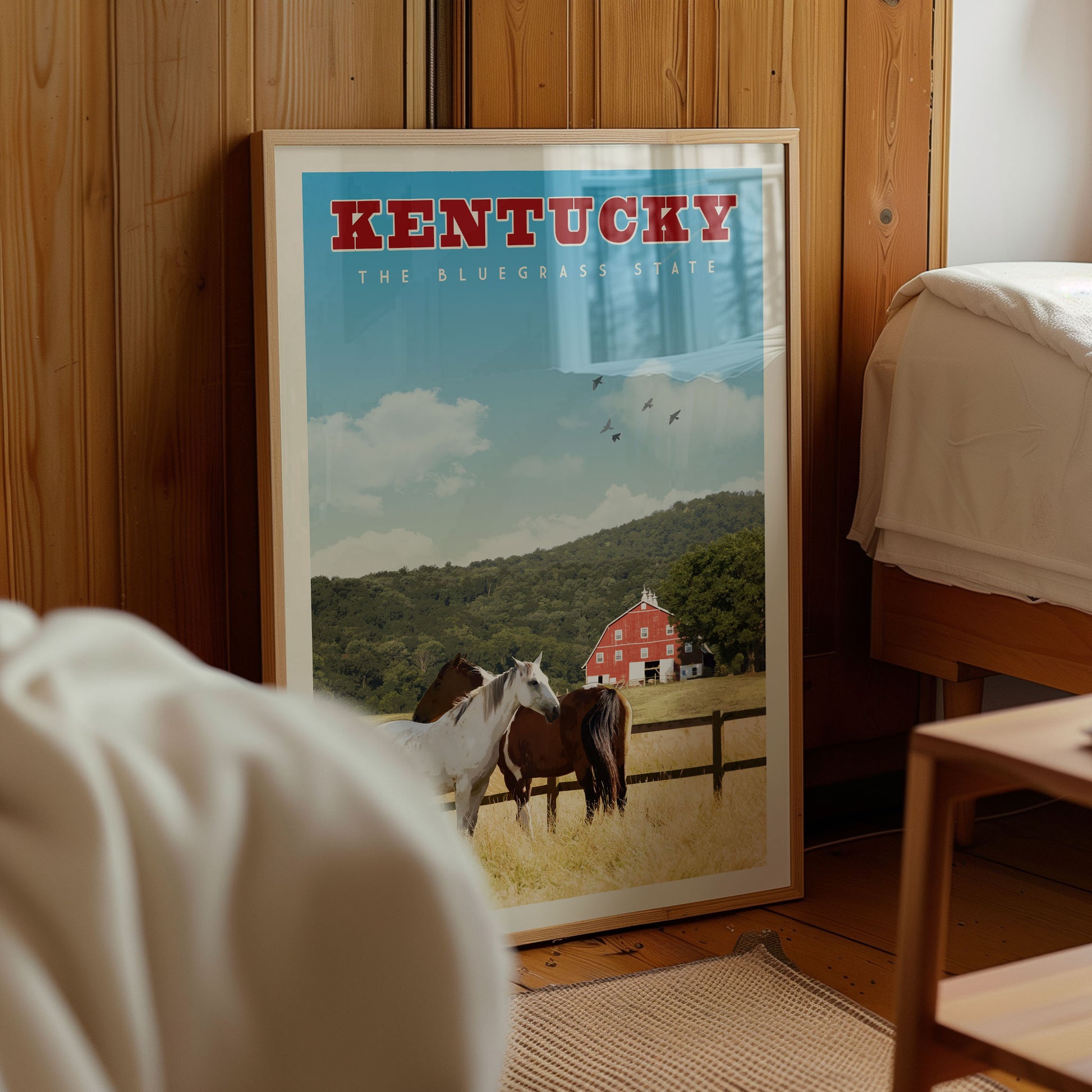 A framed poster of a rural scene with horses in a field, depicting the Kentucky Bluegrass State.