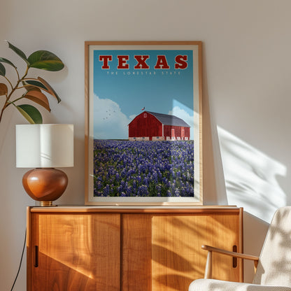a framed poster of a red barn and a field of blue flowers, with the word "TEXAS" written above it. The poster is displayed on a wooden cabinet, and there is a lamp and a plant in the foreground.
