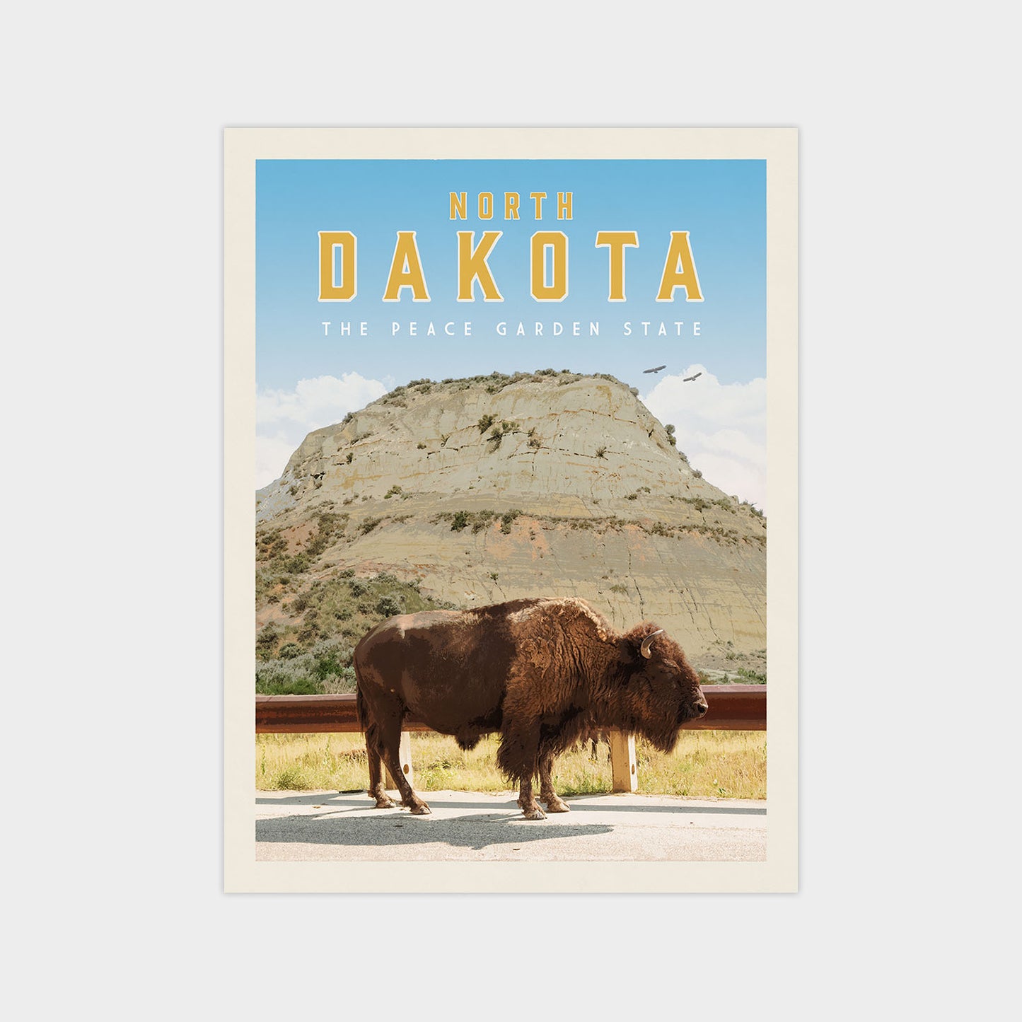 a large bison standing in a grassy field with a mountain in the background.