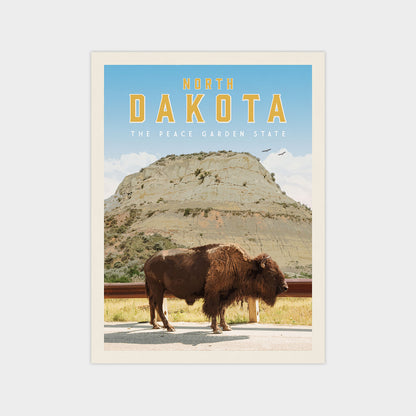a large bison standing in a grassy field with a mountain in the background.