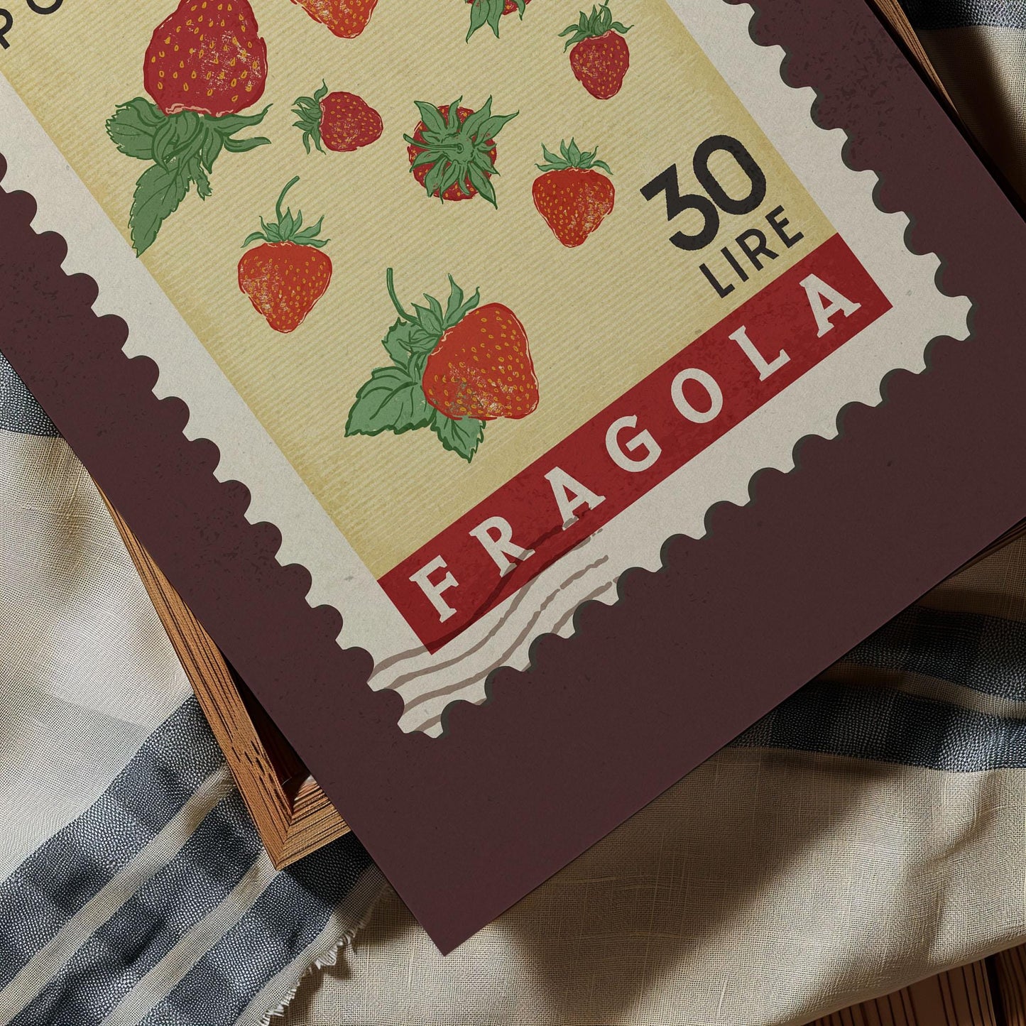 A close-up of a postage stamp featuring illustrations of strawberries, with the text &quot;FRAGOLA&quot; printed on it.